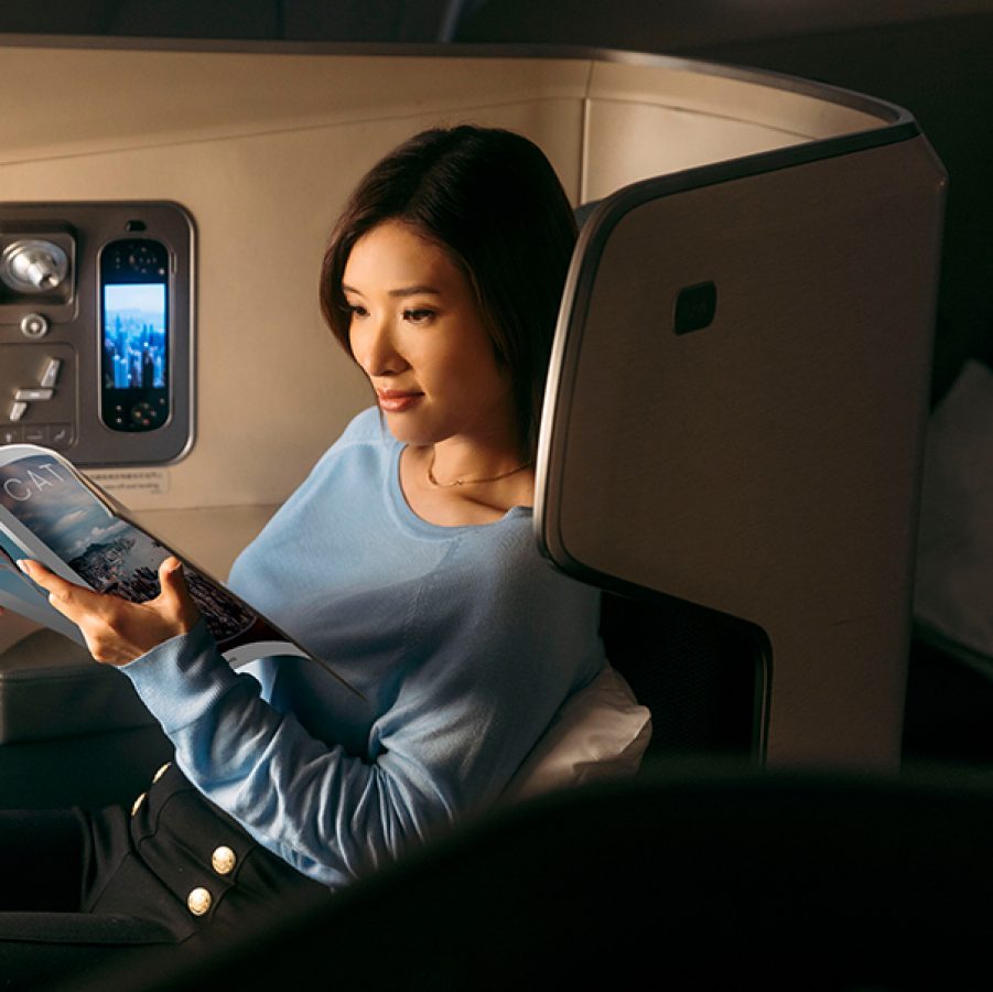 Woman reading Cathay magazine on plane